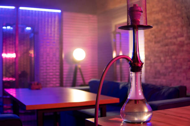 Hookah stands on the table in pink blue neon light. High quality photo